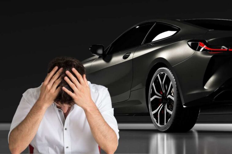 Il retro di un'auto nera e un ragazzo con le mani nei capelli