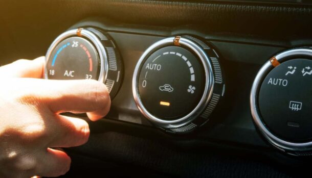 Una persona regola l'aria condizionata in auto