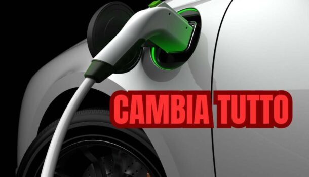 Un'auto elettrica in ricarica e la scritta "cambia tutto"