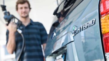 Un uomo si prepara a rifornire un'auto ibrida