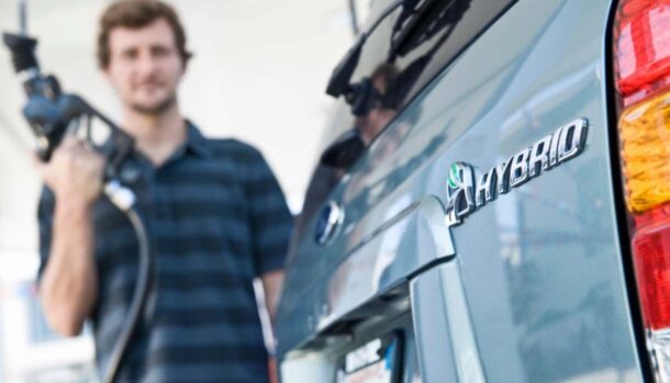 Un uomo si prepara a rifornire un'auto ibrida
