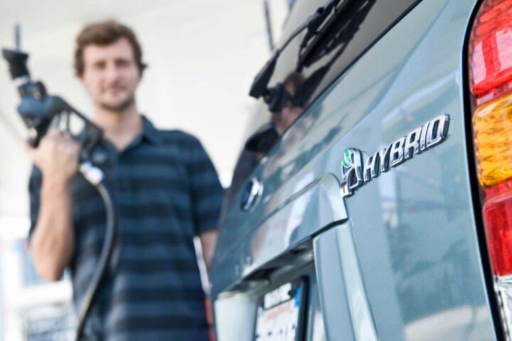 Un uomo si prepara a rifornire un'auto ibrida