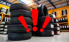 Delle pile di pneumatici e tre punti esclamativi di attenzione