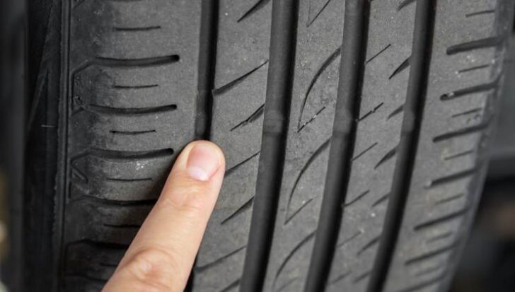 Un dito indica le scanalature delle gomme