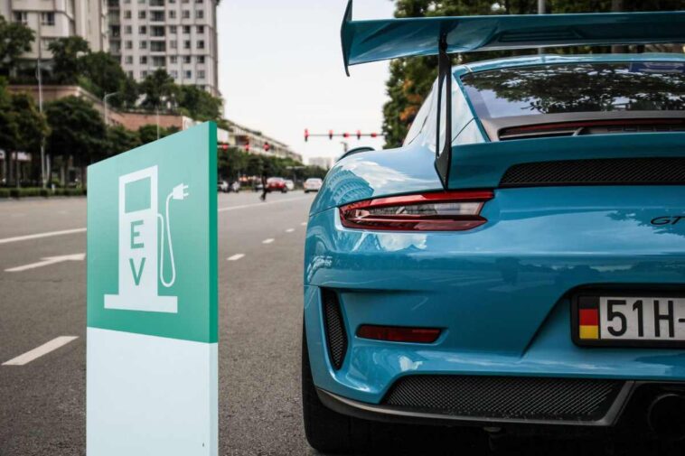 il posteriore di una Porsche e il disegno di una colonnina di ricarica