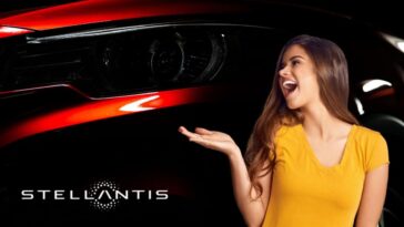 Il dettaglio di un fanale di un'auto rossa, il marchio Stellantis e una ragazza sorridente