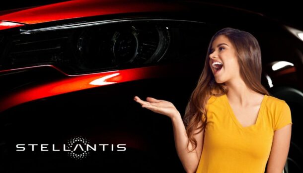 Il dettaglio di un fanale di un'auto rossa, il marchio Stellantis e una ragazza sorridente