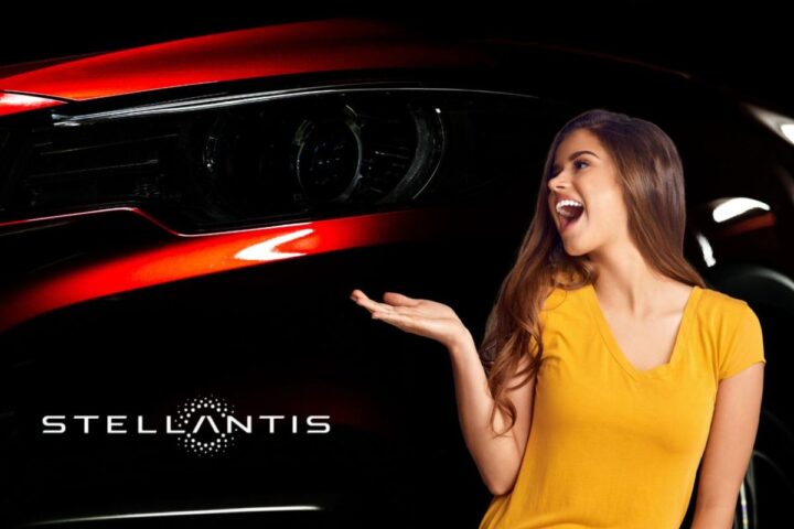 Il dettaglio di un fanale di un'auto rossa, il marchio Stellantis e una ragazza sorridente