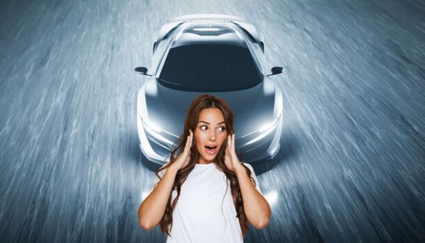 Un'auto sportiva e davanti una ragazza con espressione meravigliata