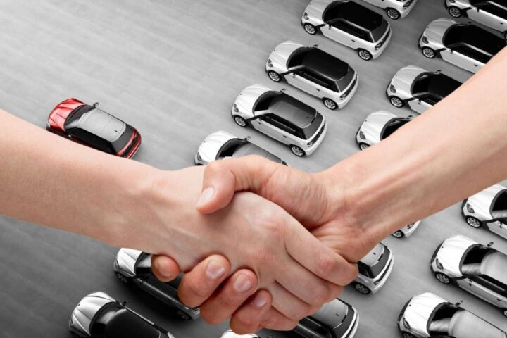 Delle auto viste dall'alto e due mani che si stringono