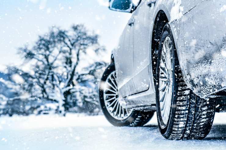 Un'auto sulla neve con pneumatici invernali