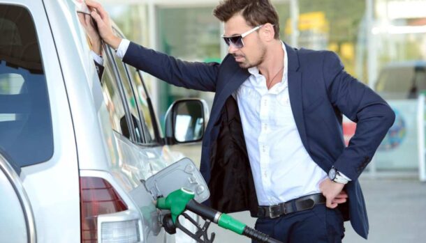 Un ragazzo appoggiato ad un'auto in fase di rifornimento