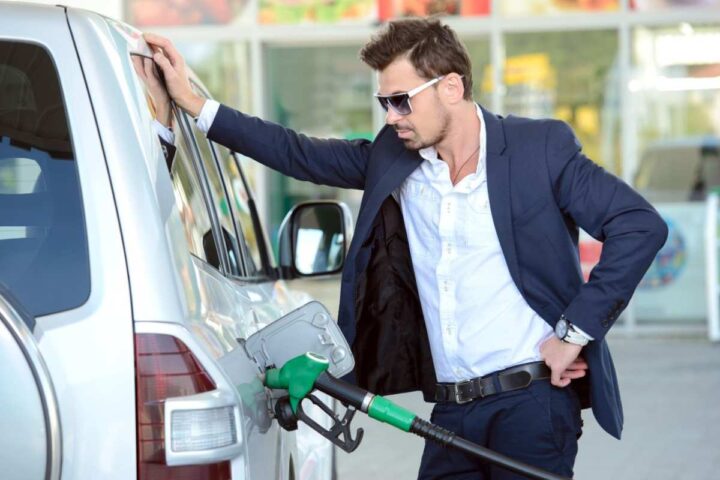 Un ragazzo appoggiato ad un'auto in fase di rifornimento