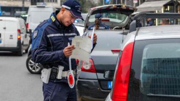 un vigile urbano controlla i documenti di un automobilista