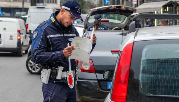 un vigile urbano controlla i documenti di un automobilista