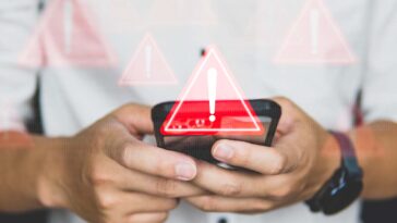 triangolo con punto esclamativo e dietro uno smartphone