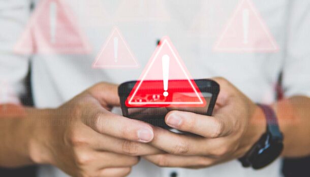 triangolo con punto esclamativo e dietro uno smartphone