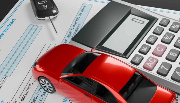 una chiave una calcolatrice e un'auto in miniatura