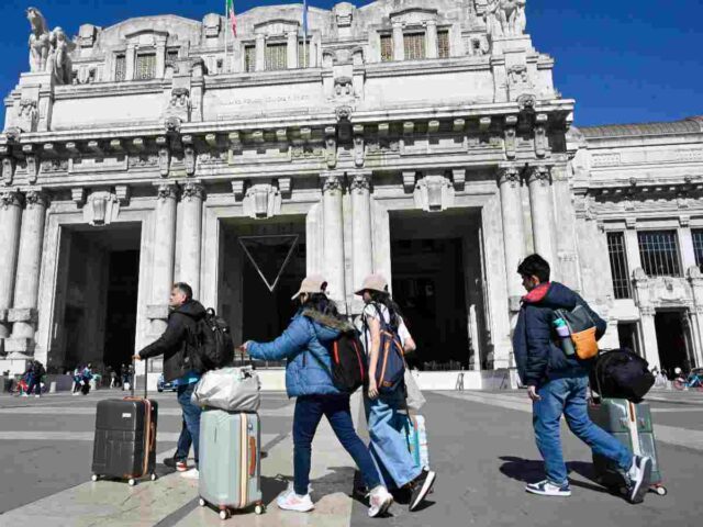 viaggiatori davanti alla stazione di Milano
